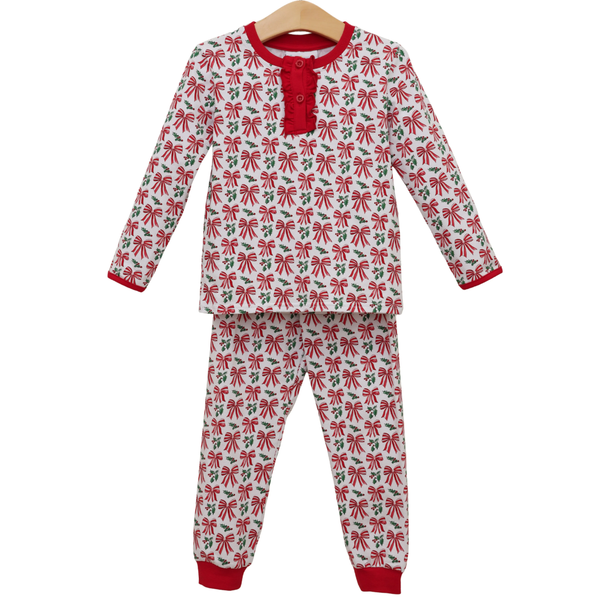 Girls long sleeve Christmas pajama set featuring an allover red bow and holly print with a ruffled button placket and matching cuffed pants.