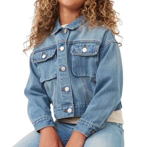 Girl wearing a medium-wash denim jacket with front pockets and snap buttons, paired with jeans.