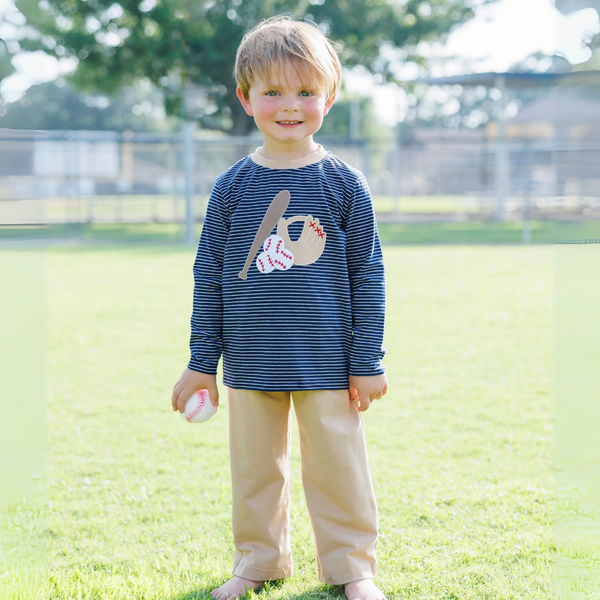Child wearing a blue striped shirt with a graphic design outdoors on grass