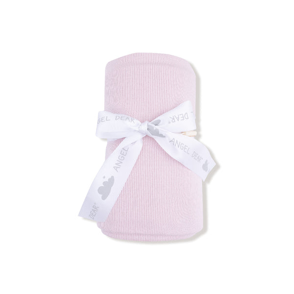 Rolled blush pink ribbed bamboo baby swaddle blanket tied with Angel Dear ribbon, shown folded and partially unrolled.

