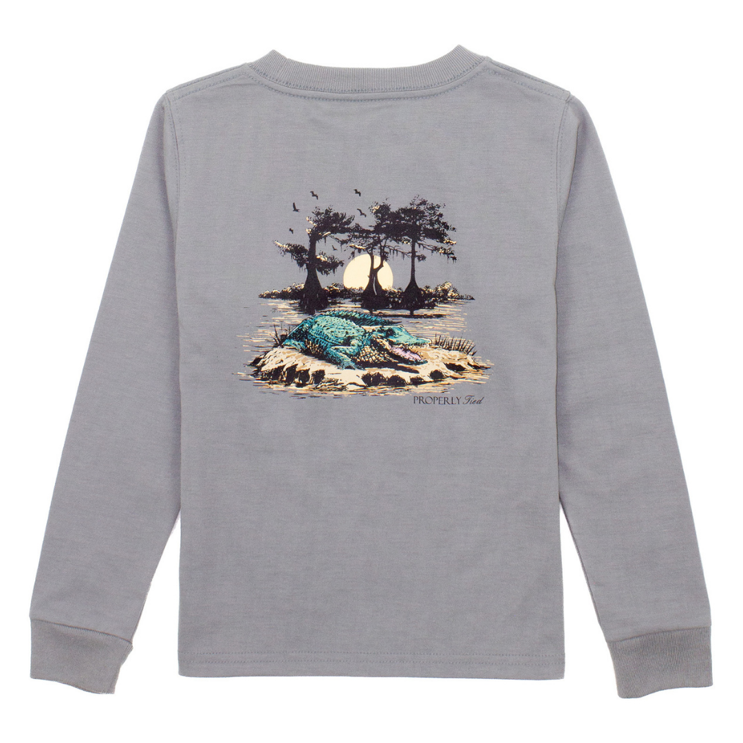 Boys’ grey long sleeve shirt with graphic of an alligator in a bayou at sunset with trees and birds

