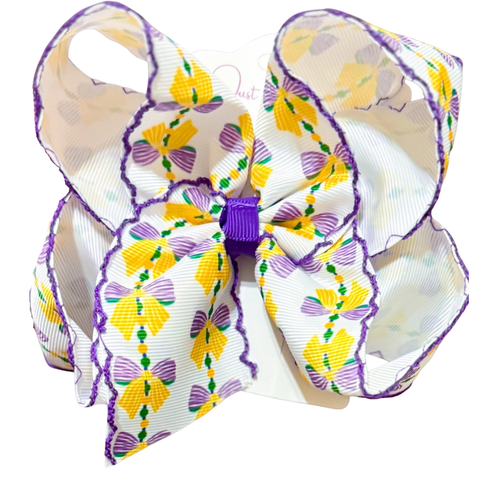 Large Mardi Gras hair bow with purple moonstitch trim and a bead-and-bow print in purple, gold, and green.