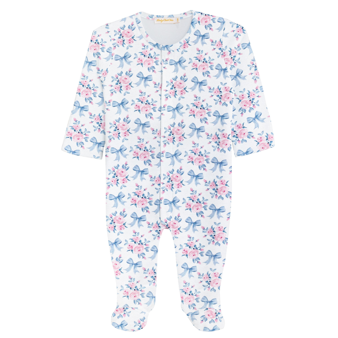 White baby footie sleeper with long sleeves, closed feet, and an allover pink floral and blue bow print pattern.