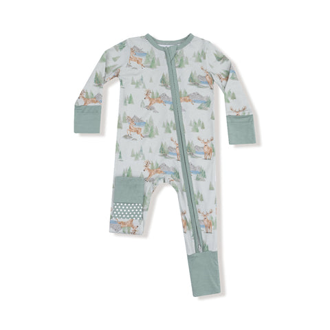 Baby romper with watercolor deer and pine tree print, green cuffs, two-way zipper, and polka dot foot and knee patches.

