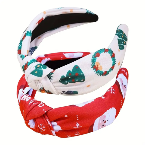 Two festive knotted headbands. The top one is white with green Christmas tree and wreath patterns. The bottom one is red with white Santa Claus faces and snowflake patterns.