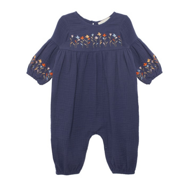 Navy baby romper with gathered tiers and embroidered flowers across the chest and sleeve cuffs.