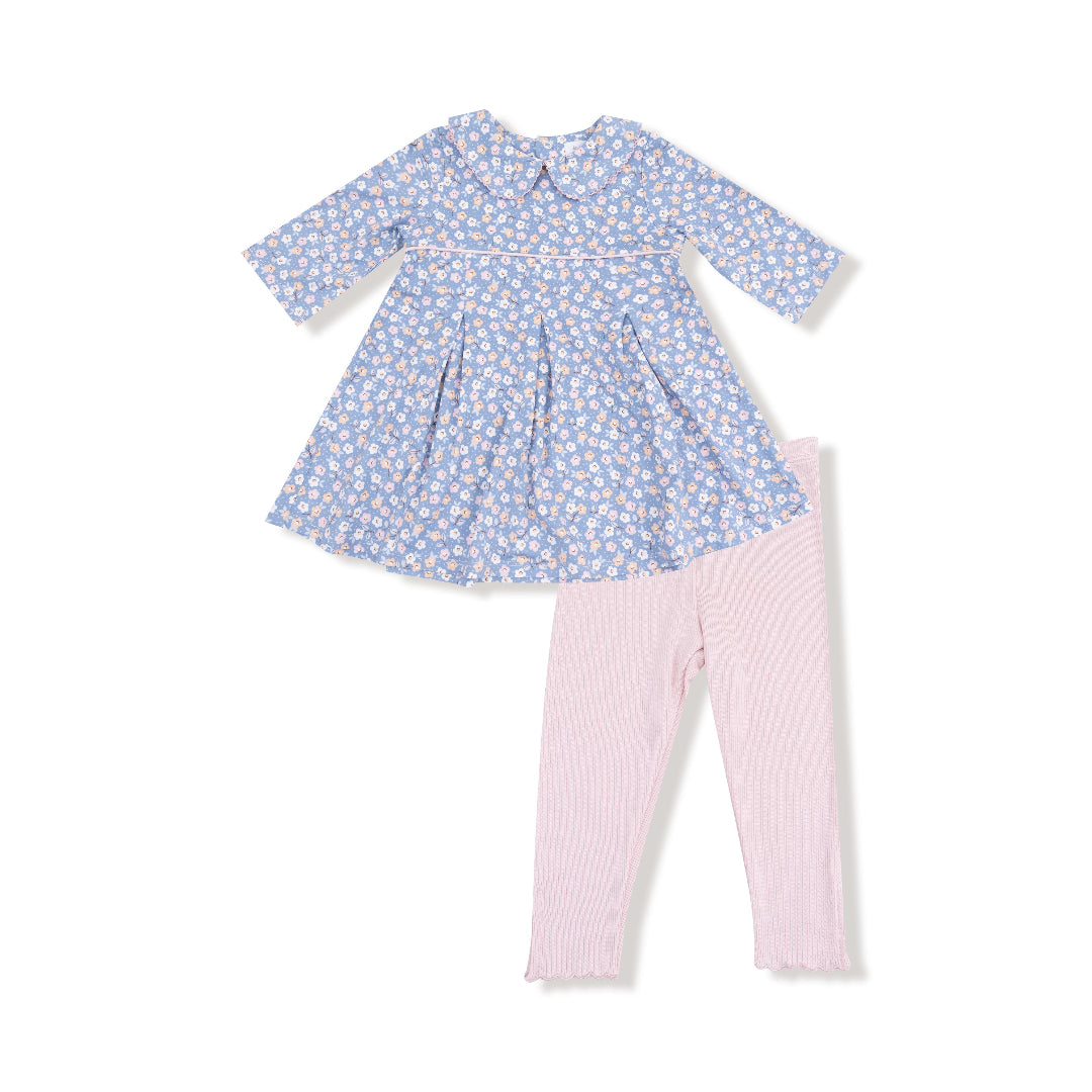 Girl’s blue floral dress with box pleats and Peter Pan collar paired with blush pink ribbed leggings featuring scalloped hems.

