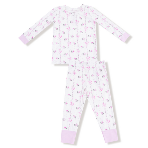 Children’s long sleeve pajama set with pink floral and bow stripe pattern and lavender cuffs, shown as a two-piece flat lay.
