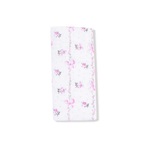 Folded blanket tied with a ribbon, showcasing the pink bow and floral stripe print

