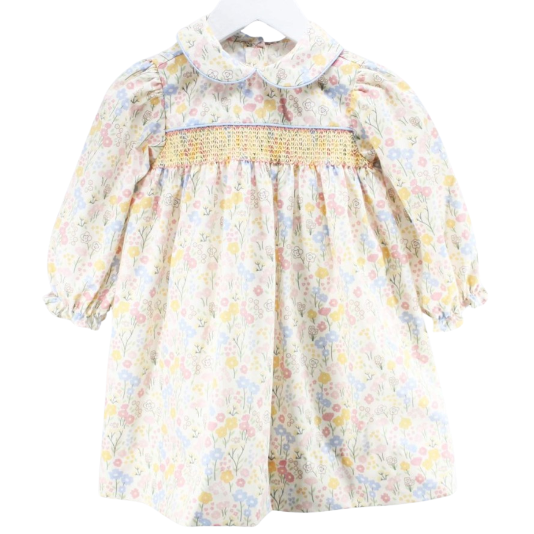 Front view of a long sleeve baby girl dress with pastel floral print and hand-smocked yellow stitching across the chest.

