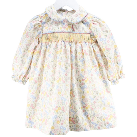 Front view of a long sleeve baby girl dress with pastel floral print and hand-smocked yellow stitching across the chest.

