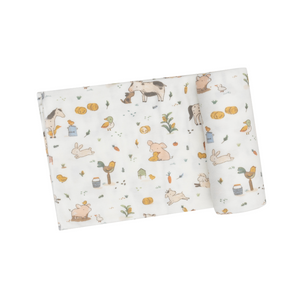 white swaddle blanket with farm animals like horses, chickens, roosters, and pigs