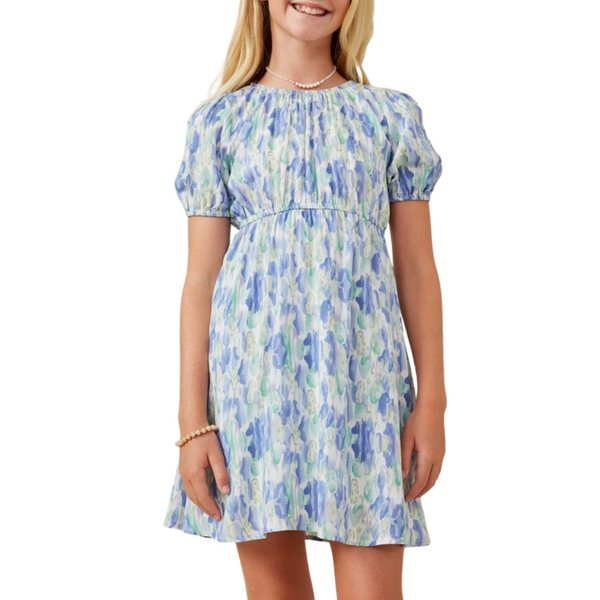 Front view: Girl wearing a blue watercolor puff sleeve dress with gathered waist