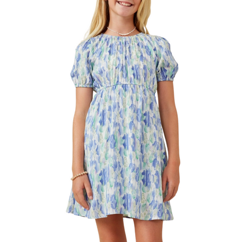 Front view: Girl wearing a blue watercolor puff sleeve dress with gathered waist