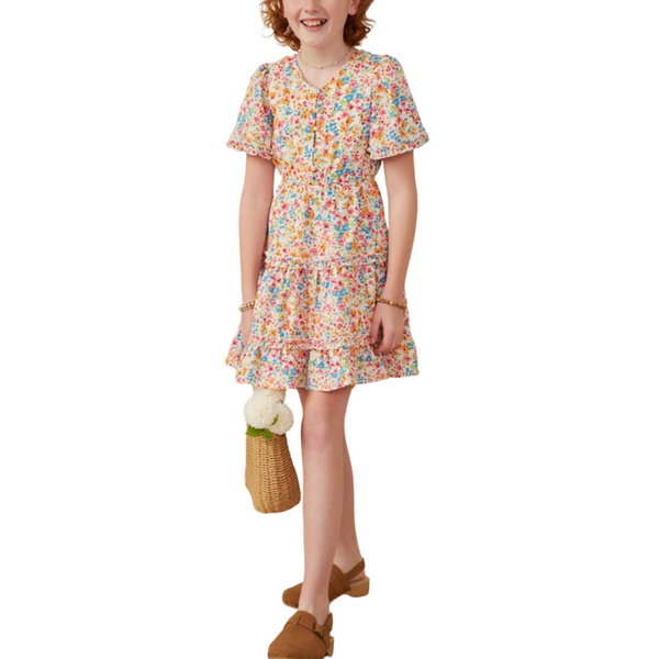 Girl in orange multi-floral dress with flutter sleeves and tiered skirt