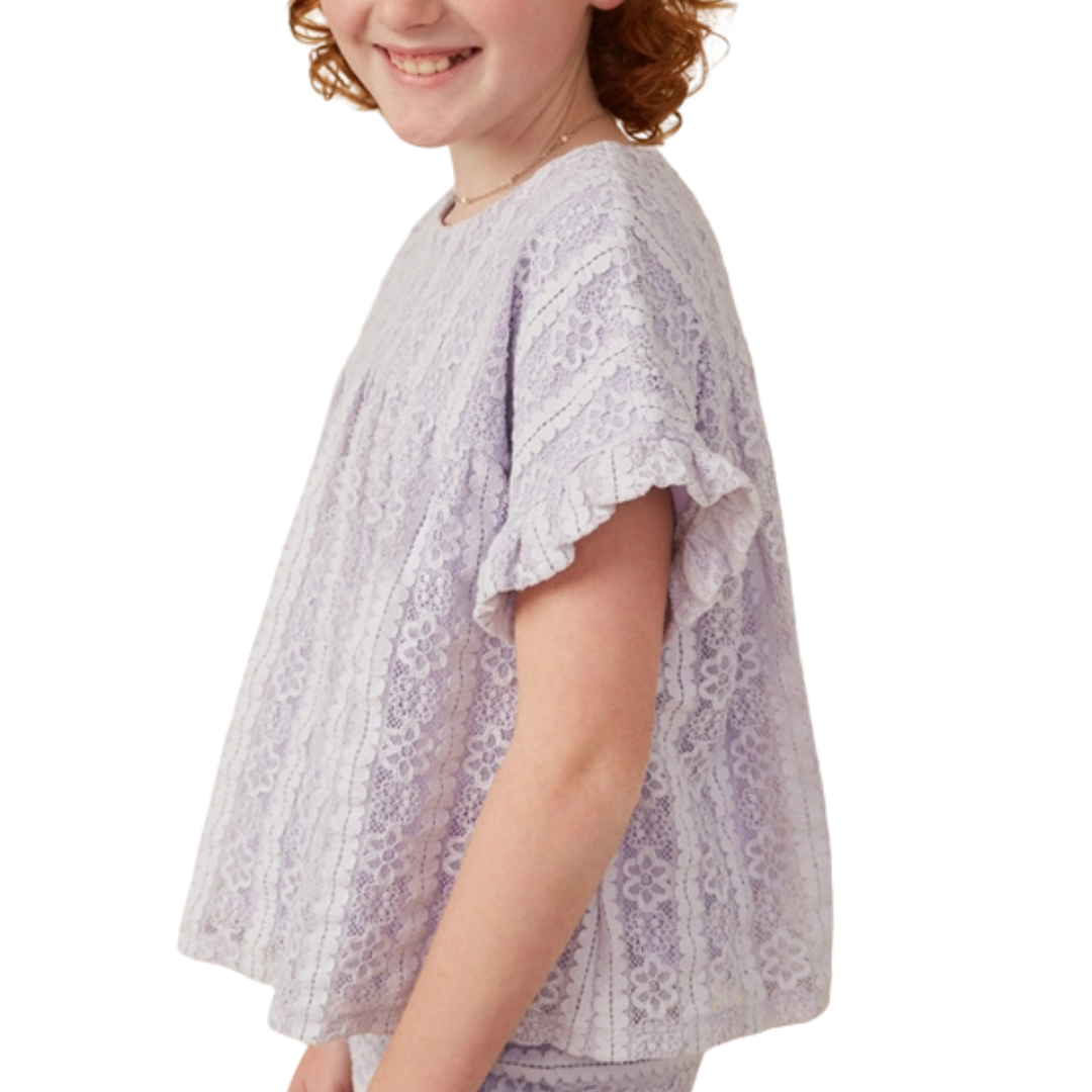 Girl wearing a lavender lace top with ruffle sleeves and floral detail, featuring a relaxed fit and back keyhole closure.