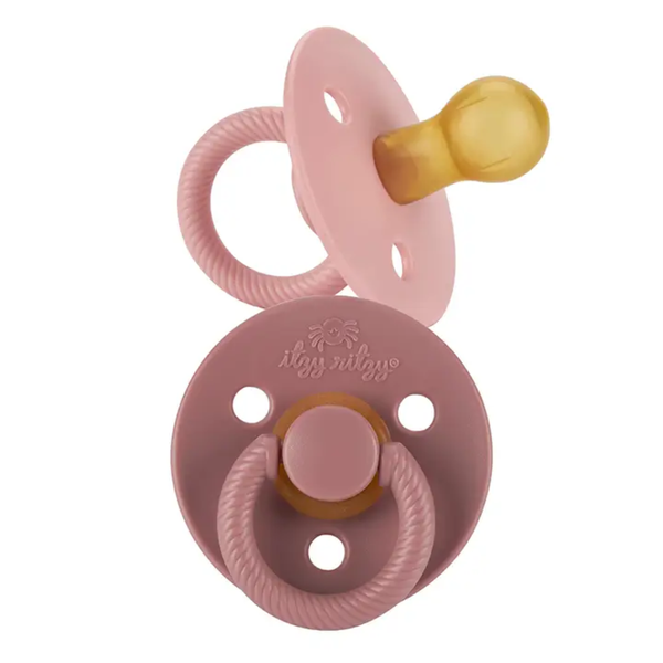 Itzy Ritzy soother pacifier in pink Blossom and Rosewood tones with natural rubber nipple and textured ring handle.