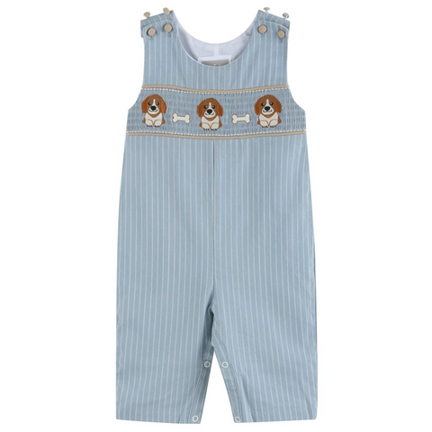 Light blue pinstripe baby boy overalls with smocked chest featuring embroidered puppies and white bones; button straps and snap legs visible.