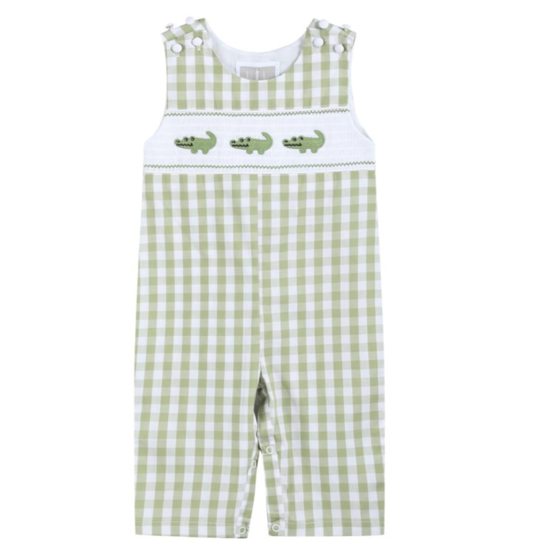 Front view of light green gingham baby overalls with three embroidered alligators on a white smocked chest panel and snap closures on the shoulders and legs
