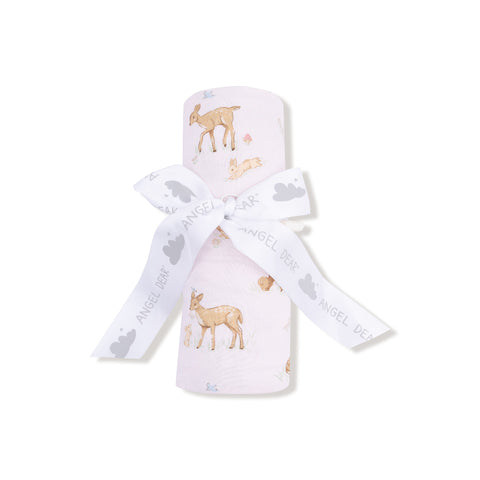 Blush pink swaddle blanket with adorable fawn and bunny print, folded with a white ribbon and shown unrolled for full pattern display.

