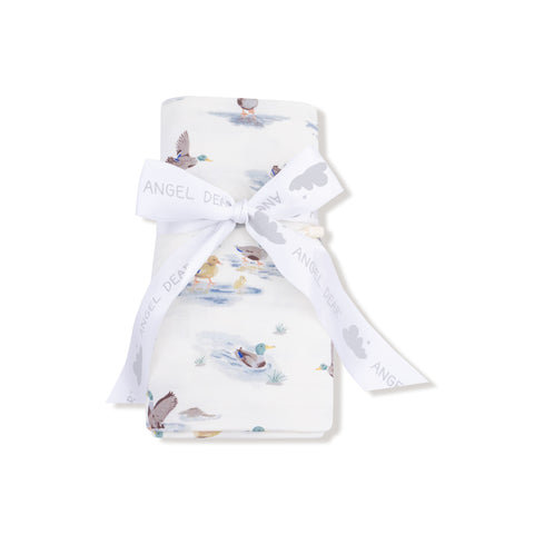 Swaddle blanket rolled and tied with a branded ribbon, mallard print visible