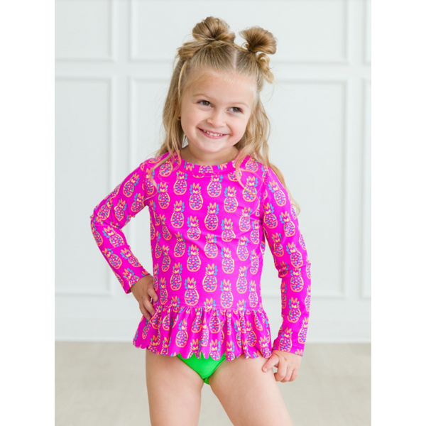 pink long sleeve rash guard with neon pineapples and matching green bottoms