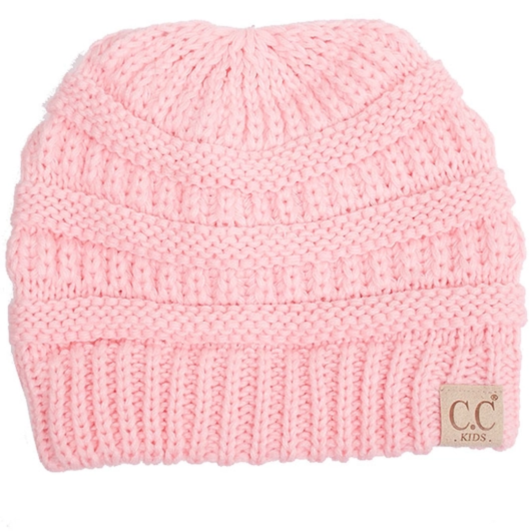 Pink knit beanie with a visible brand label on a white background