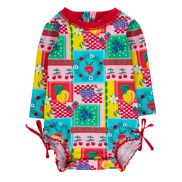 Baby girl long sleeve swimsuit with colorful fruit patchwork print, red ruffle trim, side ties, and back zipper detail.