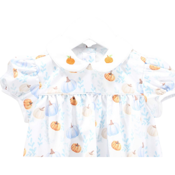 Close-up of the collar and shoulders, highlighting the embroidered pumpkins and soft pastel pumpkin print on the fabric.