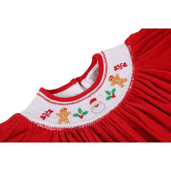 Close-up of the white smocked neckline embroidered with gingerbread men, holly, candy canes, and Santa on a red velvet Christmas dress.