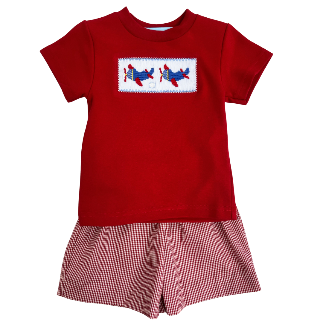 Red knit boys shirt with smocked airplanes on the front with coordinating red check shorts