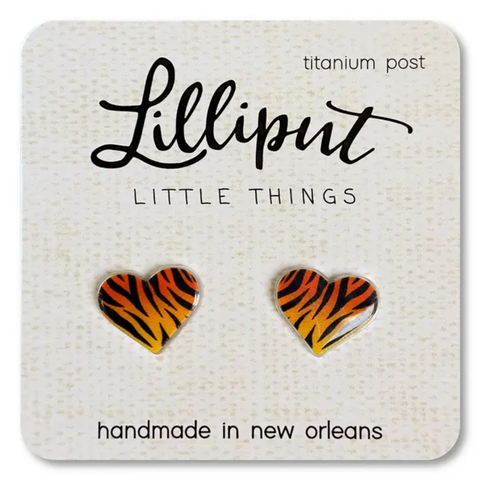 Close-up of a pair of Lilliput Little Things brand heart-shaped stud earrings with an orange and black tiger stripe pattern, displayed on a white card with 'titanium post' and 'handmade in new orleans' text.