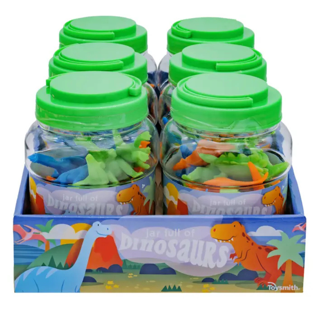 A clear plastic jar with a green lid and handle, filled with assorted colorful miniature dinosaur figures. The label on the jar shows a cartoon landscape with dinosaurs.

