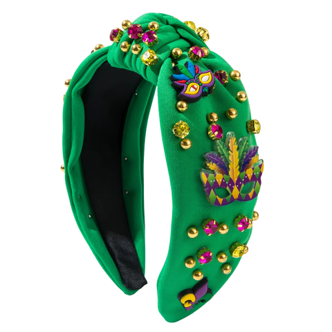 Green Mardi Gras knot headband decorated with gems, gold studs, and festive mask and feather embellishments.