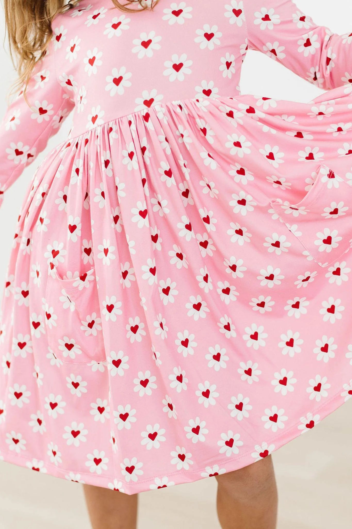 Three quarter sleeve pink twirl dress with daisy print and red heart centers