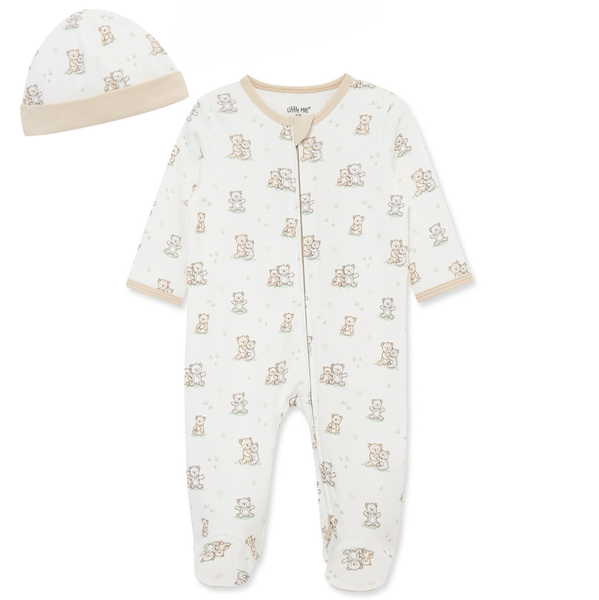 Front view of a neutral baby footed sleeper with matching beanie hat featuring an allover teddy bear print in soft beige and sage green accents.