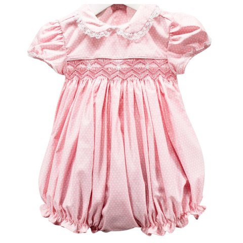 pink and white small dotted fabric in a baby bubble.  Bodice smocked with geometric smocking, short sleeves and collar trimmed in a delicate lace