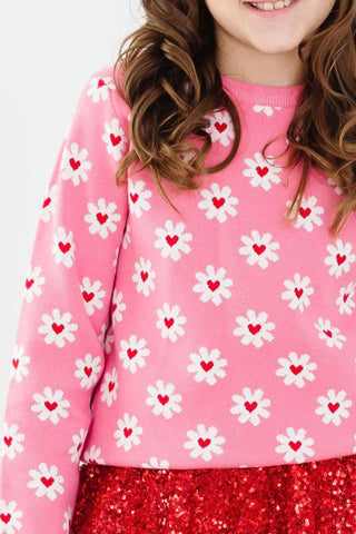long sleeve pink sweater with daisy print in white and a red heart in the center of the daisy